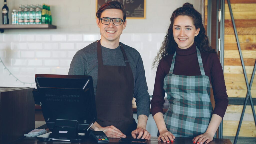 Cafe staff smiling at the counter, ready to assist customers.